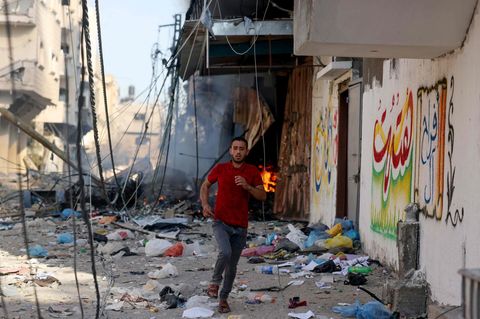Israel bombardiert Gaza: Ein Mann rennt vor den Einschlägen weg
