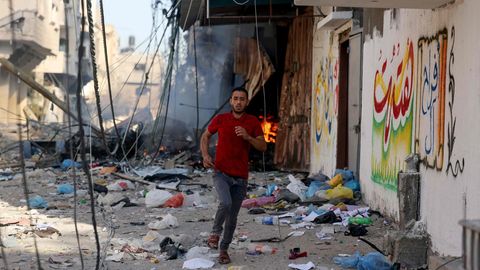 Israel bombardiert Gaza: Ein Mann rennt vor den Einschlägen weg