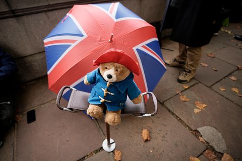 Ein Paddington Bär-Stofftier vor einem Regenschirm mit den Farben des Union Jack