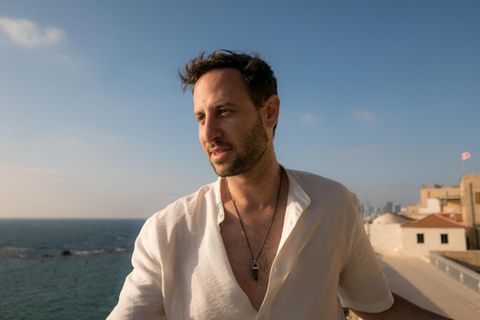 Elad Mintzer steht in Tel Aviv-Jaffa, im Hintergrund ist Meer zu sehen.