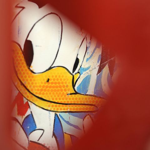 Bild von Donald Duck, umrandet von einer unscharfen roten Skulptur im Vordergrund