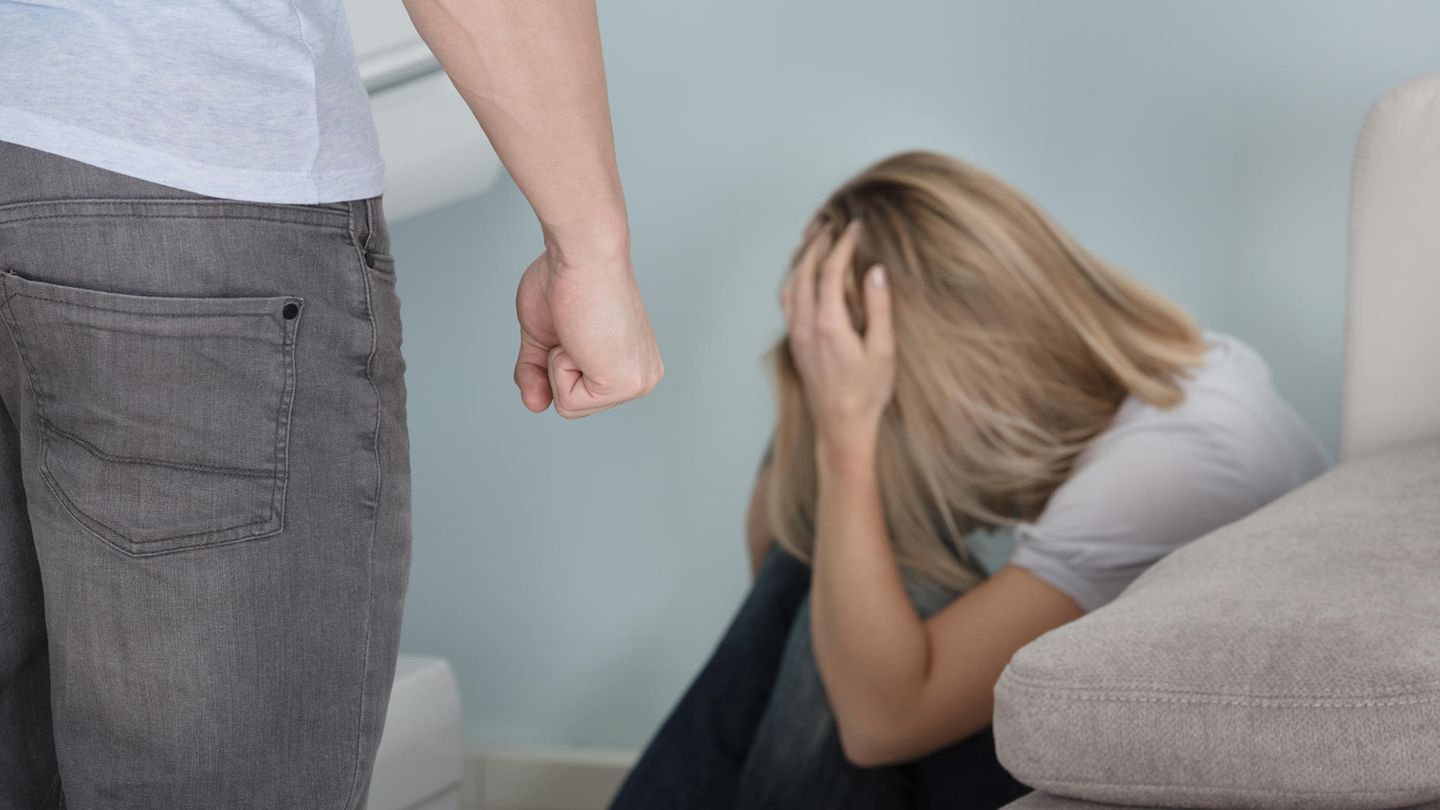 Femizide: Mann steht vor einer verängstigten Frau und ballt die Faust Femizide: Mann steht vor einer verängstigten Frau und ballt die Faust