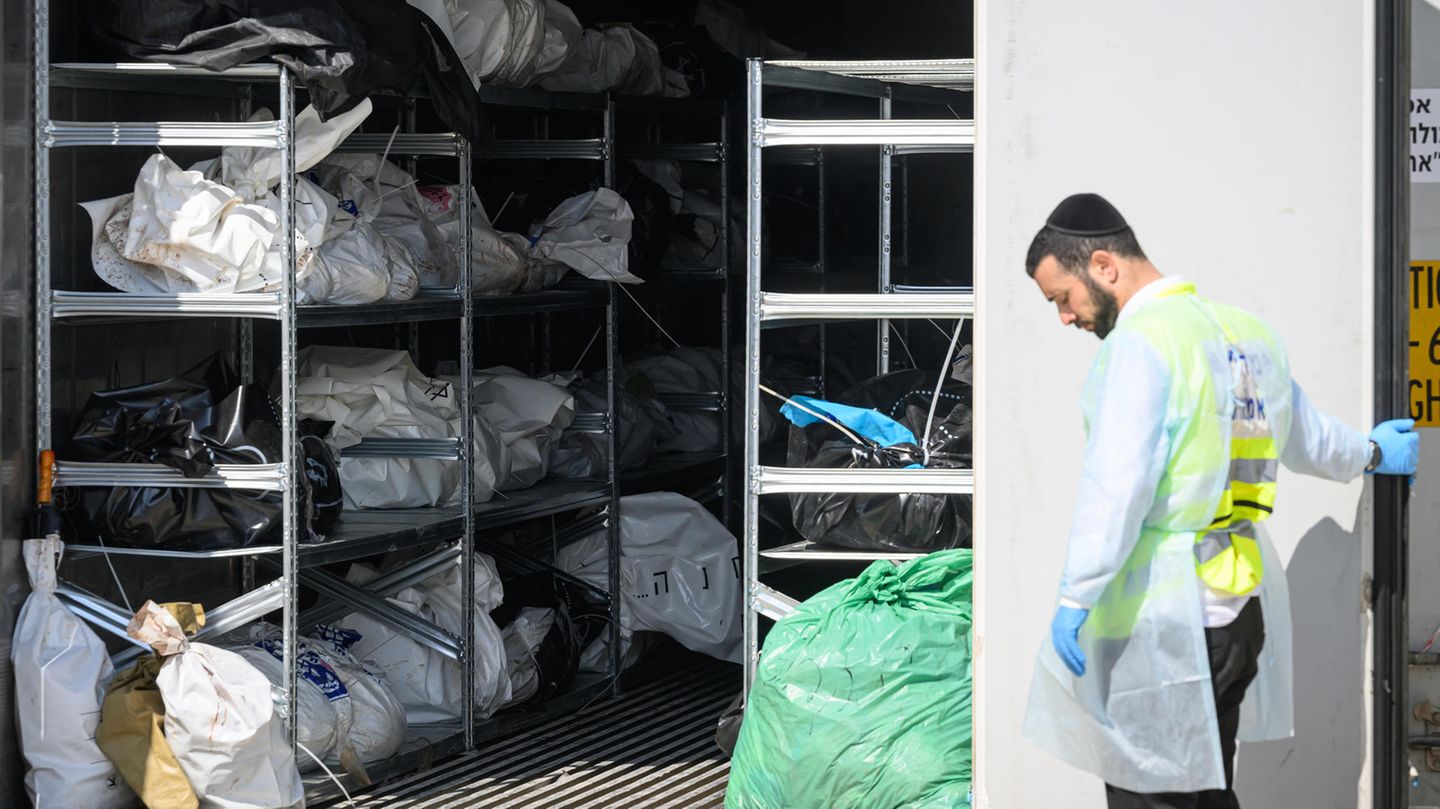 Ein Mitarbeiter der Rechtsmedizin steht vor einem Kühlcontainer mit den Leichen israelischer Bürger