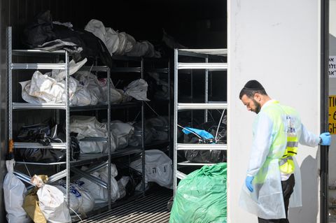 Ein Mitarbeiter der Rechtsmedizin steht vor einem Kühlcontainer mit den Leichen israelischer Bürger