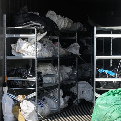 Ein Mitarbeiter der Rechtsmedizin steht vor einem Kühlcontainer mit den Leichen israelischer Bürger
