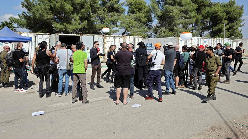 Journalisten berichten, während Forensik-Teams und Soldaten der Presse die Leichen der israelischen Opfer zeigen