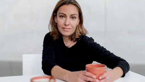 Joana Osman: Eine Frau hält eine Tasse in der Hand