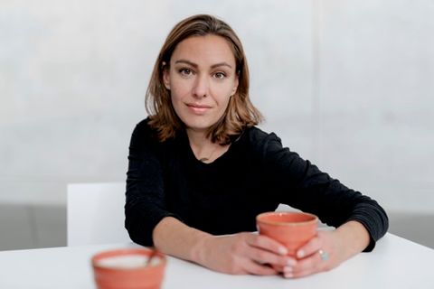 Joana Osman: Eine Frau hält eine Tasse in der Hand