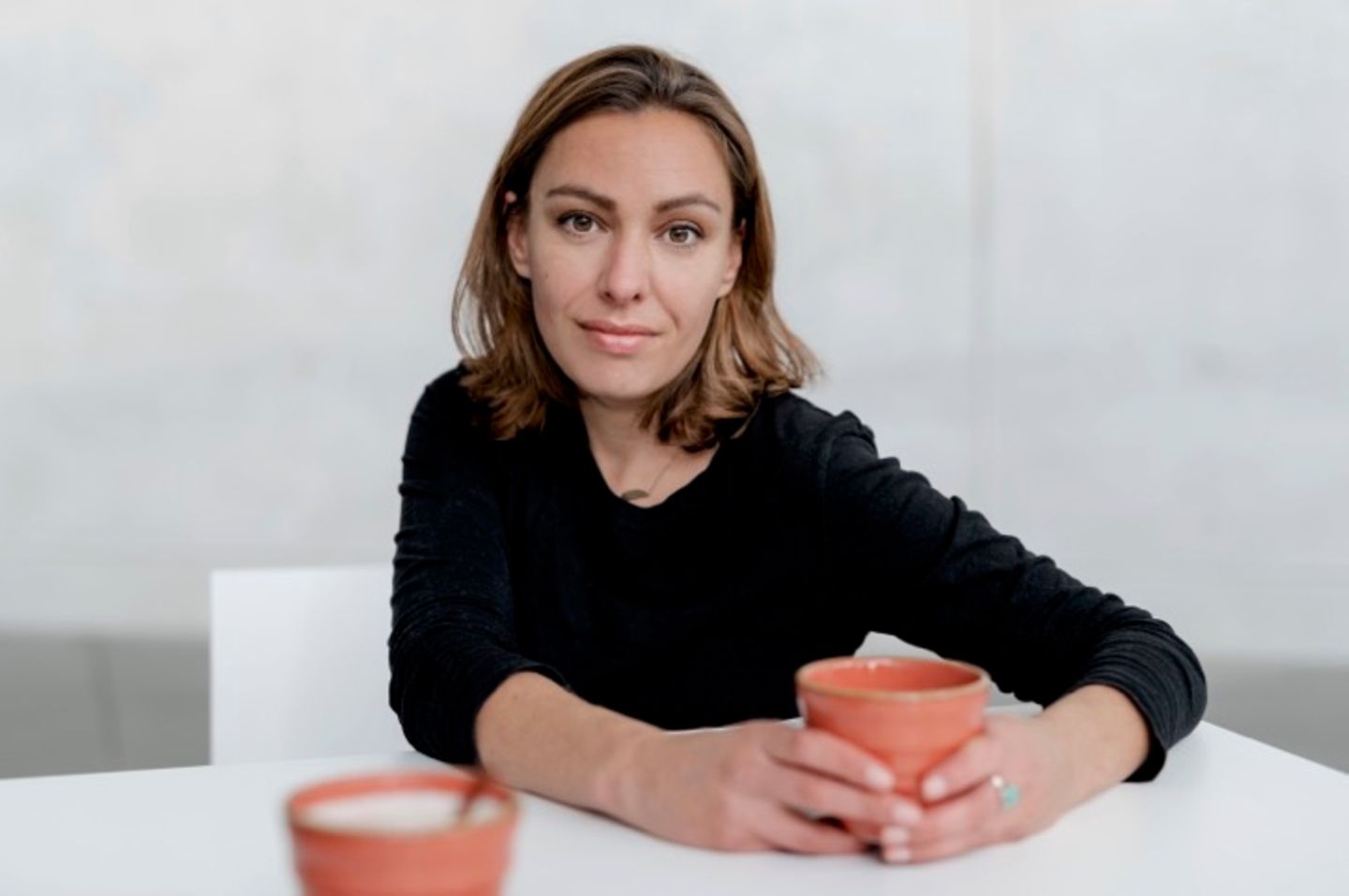 Joana Osman: Eine Frau hält eine Tasse in der Hand