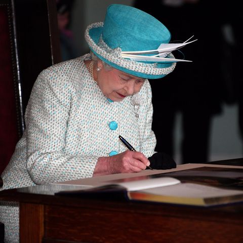 Queen Elizabeth II unterschreibt ein Dokument
