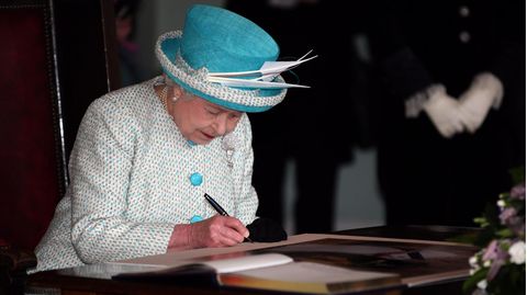 Queen Elizabeth II unterschreibt ein Dokument
