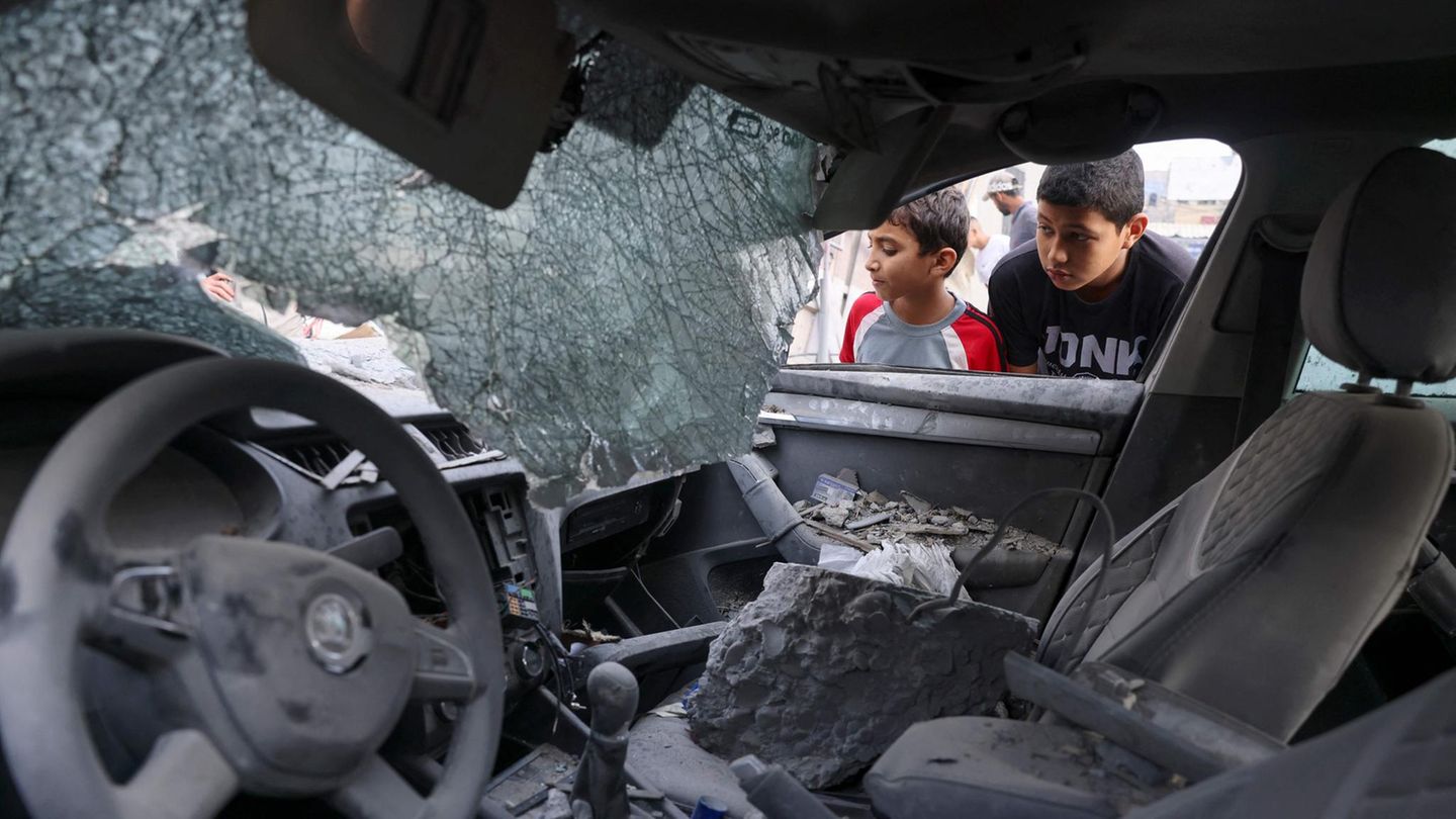 Kinder inspizieren ein zerstörtes Auto in Khan Yunis im südlichen Teil des Gazastreifens 