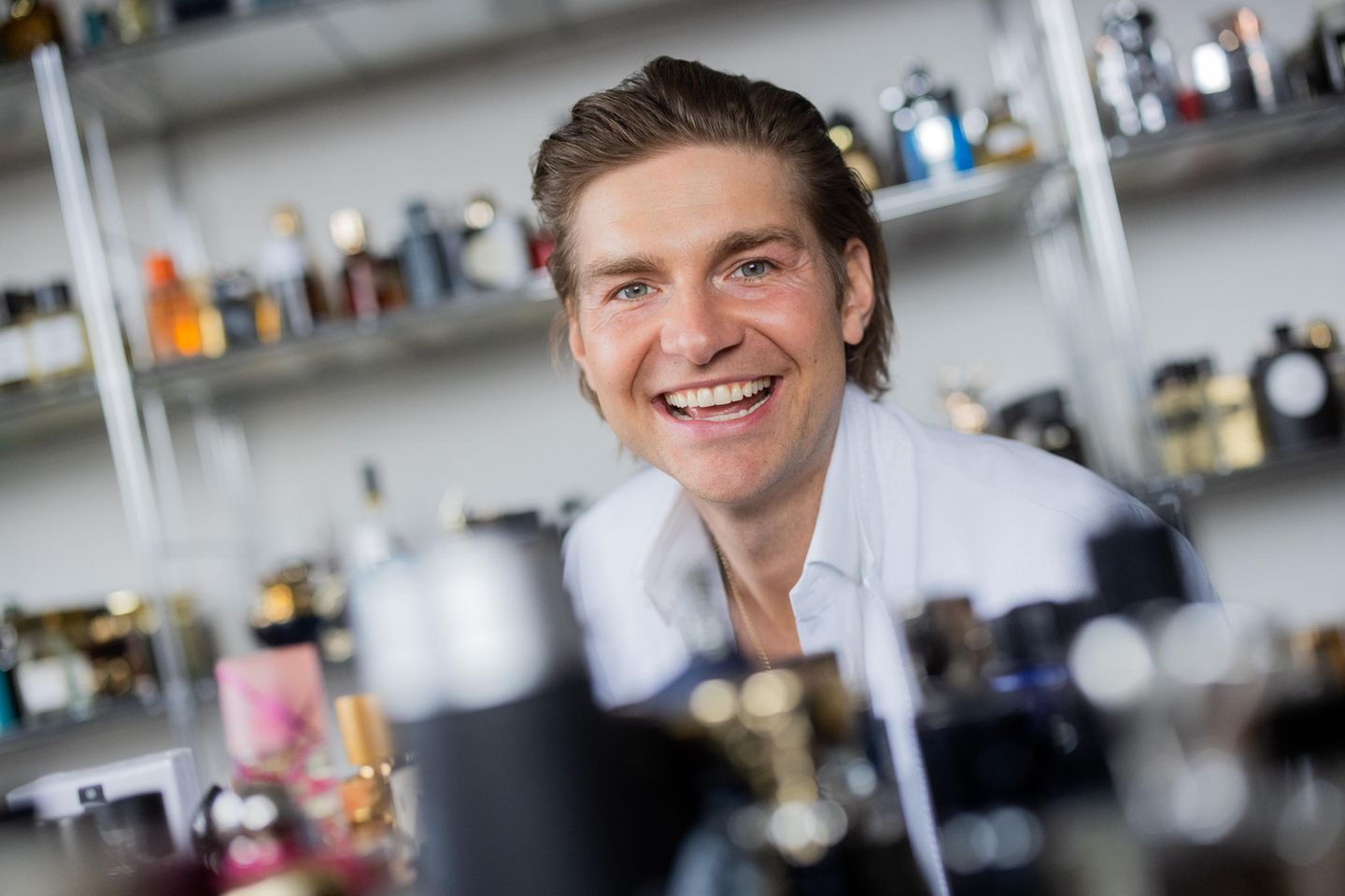 Parfum-Blogger Jeremy Fragrance, 34, im weißen Anzug vor einem Regal mit Düften