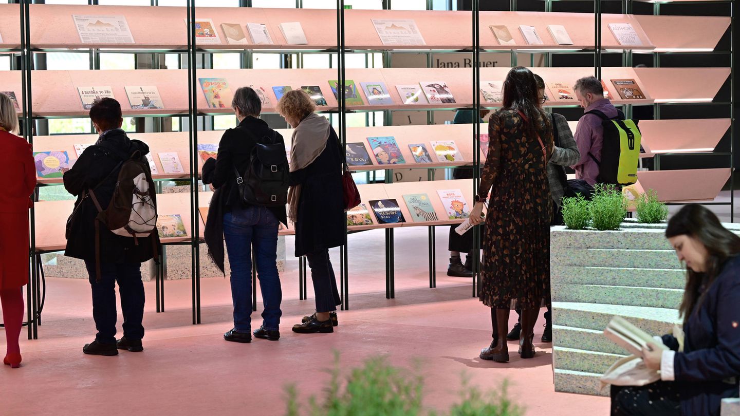 Menschen stöbern in einem Regal auf der Frankfurter Buchmesse