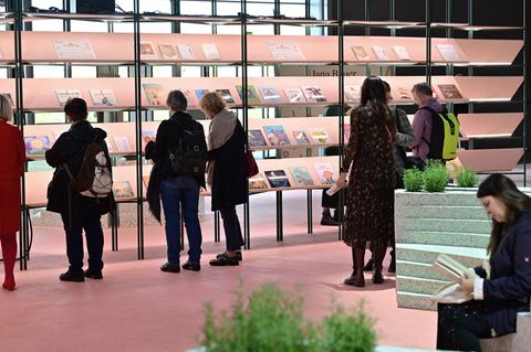 Menschen stöbern in einem Regal auf der Frankfurter Buchmesse