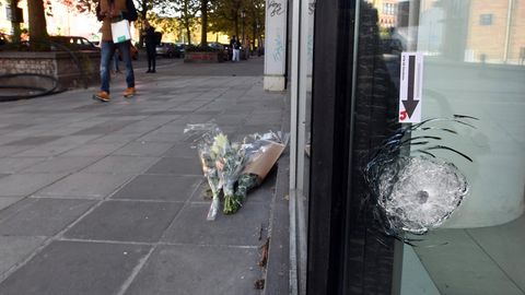 Blumen liegen am Tatort des Attentats in Brüssel, bei dem zwei Schweden getötet wurden. Ein Einschussloch ist zu erkennen