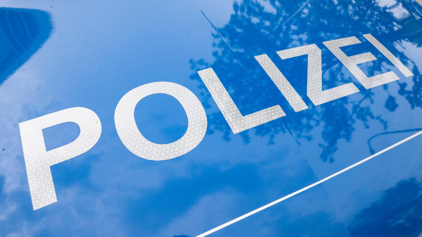 Polizei steht in weißen, reflektierenden Buchstaben auf der blauen Motorhaube eines Autos in Hessen