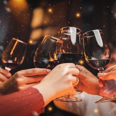 Eine Gruppe stößt mit Wein aus einem Wein-Adventskalender an