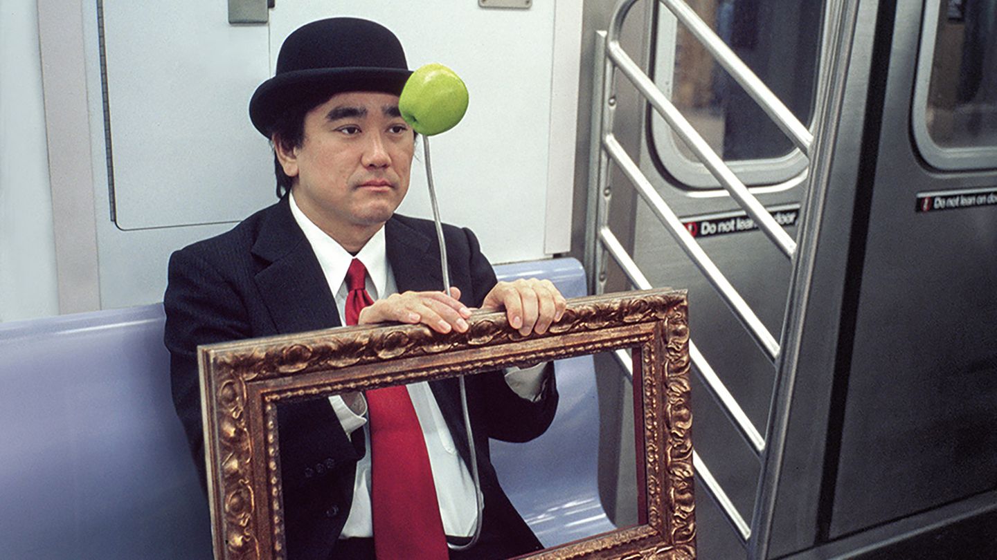 Ein Mann in der U-Bahn in New York ist als René Magritte's Gemälde "Der Sohn des Mannes" verkleidet