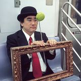 Ein Mann in der U-Bahn in New York ist als René Magritte's Gemälde "Der Sohn des Mannes" verkleidet