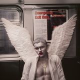 An Halloween sitzt ein verkleideter silber bemalter Engel in einer U-Bahn in New York