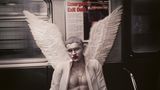 An Halloween sitzt ein verkleideter silber bemalter Engel in einer U-Bahn in New York