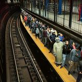 Zwischen vielen unverkleideten Männern steht ein als Wolf von Rotkäppchen verkleideter an einem Bahnsteig in New York