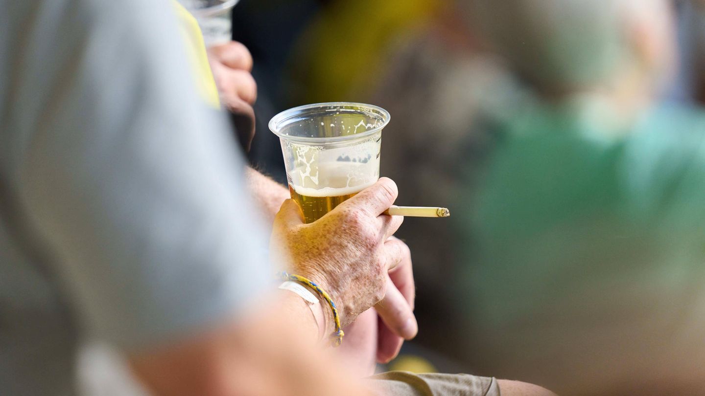 Rauchverbot: Ein Mann mit Bier und Zigarette im Stadion