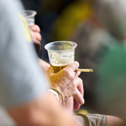 Rauchverbot: Ein Mann mit Bier und Zigarette im Stadion