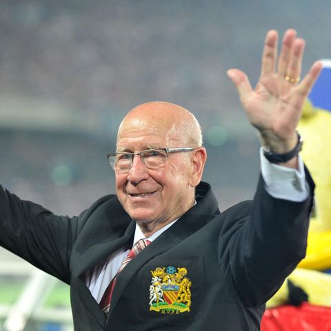 Sir Bobby Charlton, 2013, hebt im Stadion die Hände und winkt den Zuschauern zu
