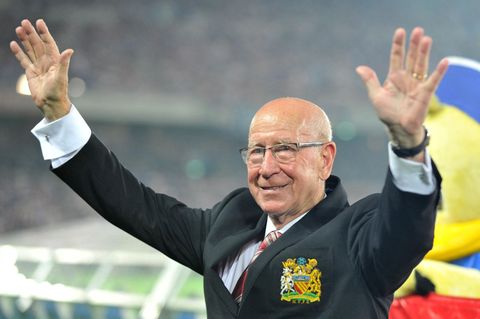 Sir Bobby Charlton, 2013, hebt im Stadion die Hände und winkt den Zuschauern zu
