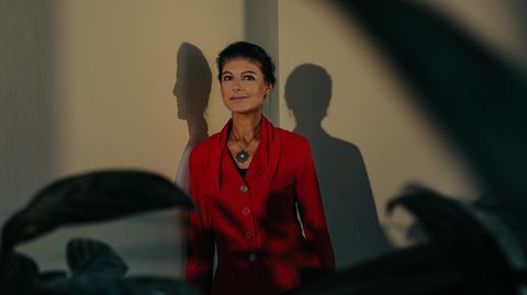 Sahra Wagenknecht, 54, lehnt an einer Wand, vor ihr Pflanzen