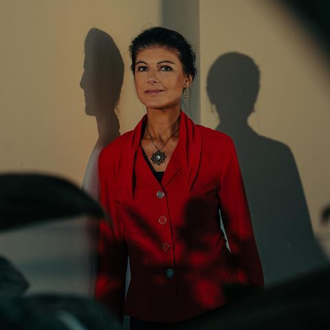 Sahra Wagenknecht, 54, lehnt an einer Wand, vor ihr Pflanzen