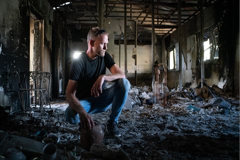Ori Rubin kniet im ausgebrannten Haus seiner Eltern in Nir Oz zwischen Schutt