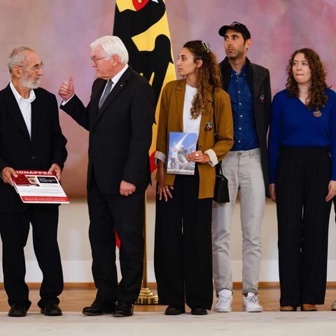Bundespräsident Frank-Walter Steinmeier (M.) mit dem israelischen Botschafter Ron Prosor (l.) und Familien von entführten deutsch-israelischen Staatsbürgern. Rechts im Bild: die Schwester der entführten Yarden, Roni Roman, daneben Bruder Gili und Cousine Maya (r.)