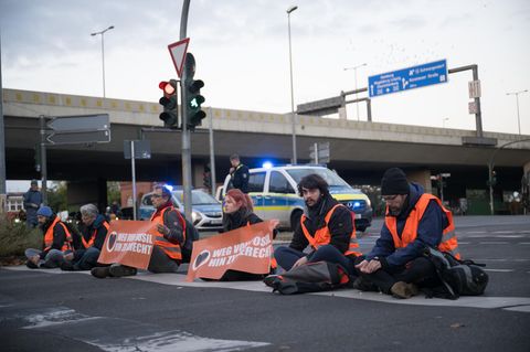  Aktivisten kleben während einer Straßenblockade der Klimaschutzgruppe "Letzte Generation" an einer Abfahrt der A100 in Berlin