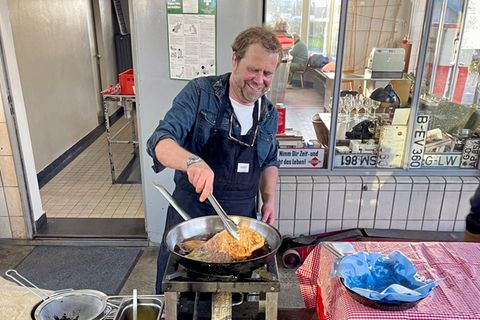 Koch Lutz Bornhöft brät Schnitzel in einer Werkstatt