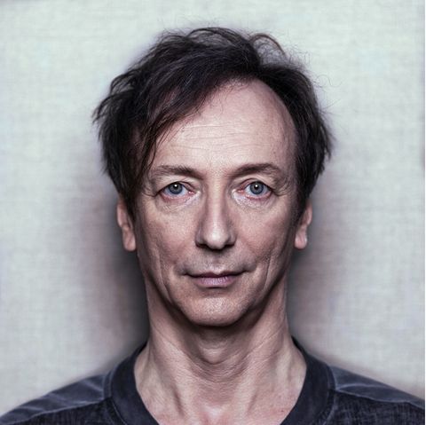 Ein Porträt von Volker Bertelmann, einem schlanken Mann mit braunen Haaren
