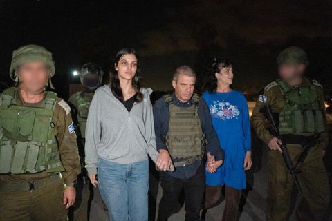 Zwei Frauen gehen zwischen Soldaten – es sind die beiden von der Hamas freigelassenen Geiseln Judith und Natalie Raanan