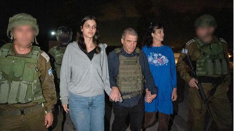 Zwei Frauen gehen zwischen Soldaten – es sind die beiden von der Hamas freigelassenen Geiseln Judith und Natalie Raanan