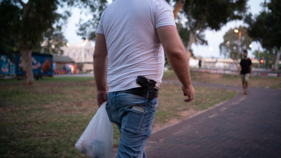 Ein Mann trägt eine Schusswaffe im Gürtel