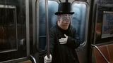 Ein Mann steht an Halloween mit einer Vertigo Maske in einer NewYorker U-Bahn