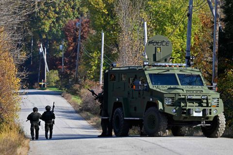 Schwer bewaffnet fahnden Polizisten nach dem mutmaßlichen Täter in Maine. Am Freitagabend wurde er tot in einer Stadt unweit der Tatorte aufgefunden.