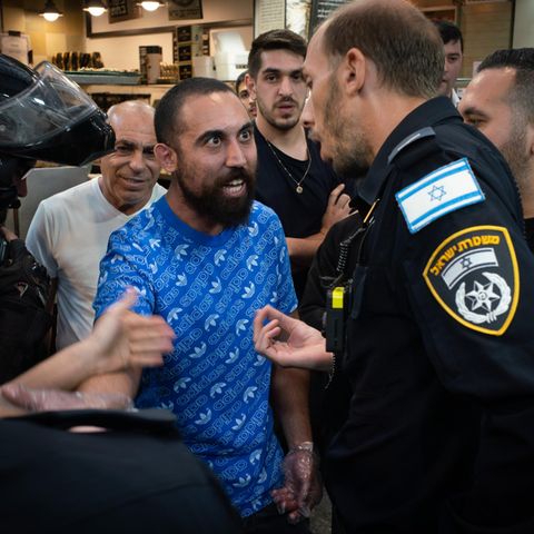 Streit auf dem Yehuda-Markt in Jerusalem: Ein Verkäufer wird nach einem Tumult von der Polizei vom Markt eskortiert