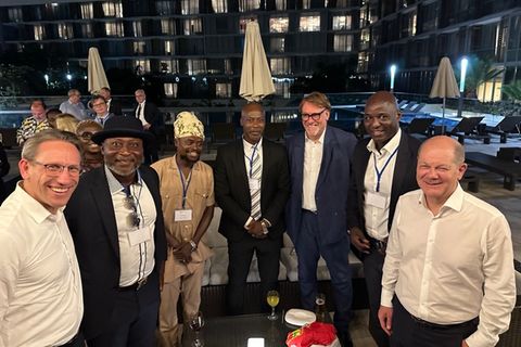Kanzler Scholz mit Ex-Bundesliga-Stars Yeboah (zweiter von links), Tanko (Mitte), Baffoe.