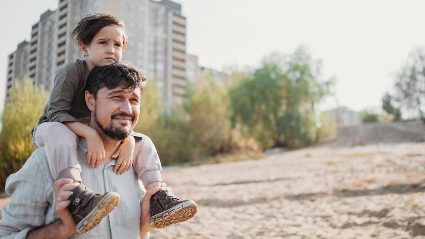 Studie: Ein junger Vater trägt einen Jungen auf den Schultern