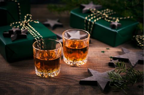 Rum-Adventskalender: Zwei mit Rum befüllte Gläser stehen neben Geschenken und weihnachtlicher Deko
