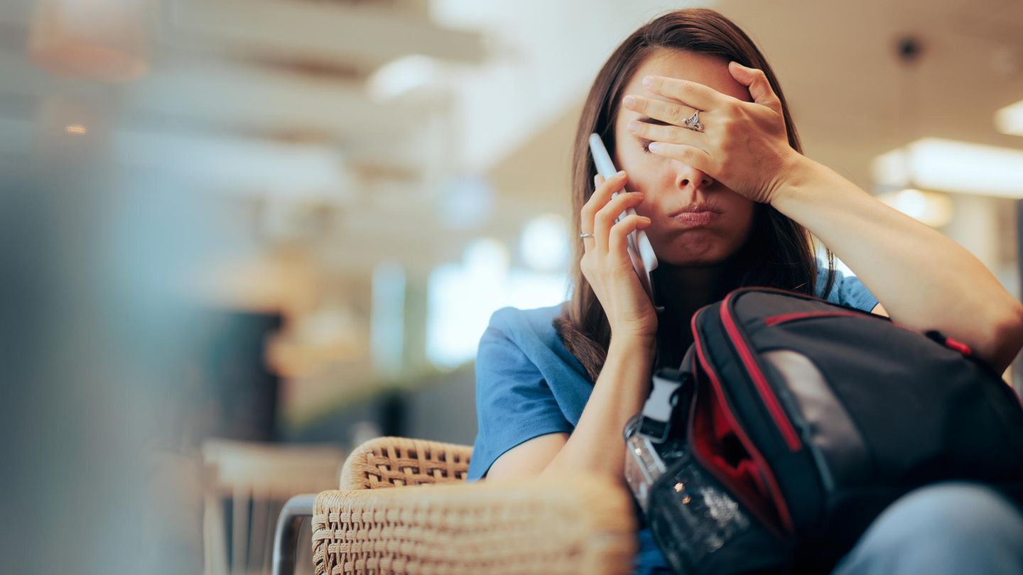 Eine Frau telefoniert und hält sich die Augen zu