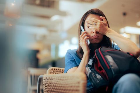 Eine Frau telefoniert und hält sich die Augen zu