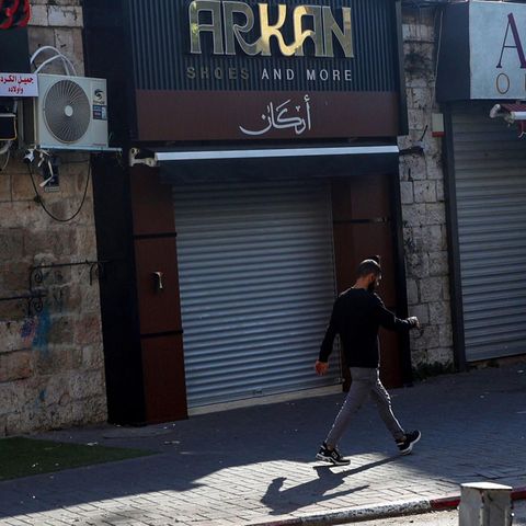 A man runs past closed shops